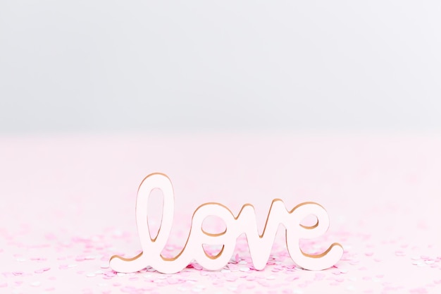 Signo de amor del día de San Valentín en un fondo rosa.