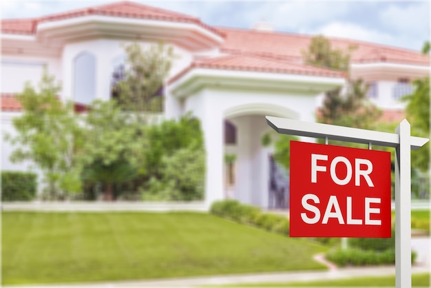 Foto signo de bienes raíces frente a casa nueva en venta