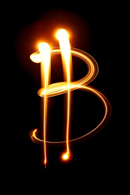 Signo de Bitcoin sobre fondo negro. Pintura de luz