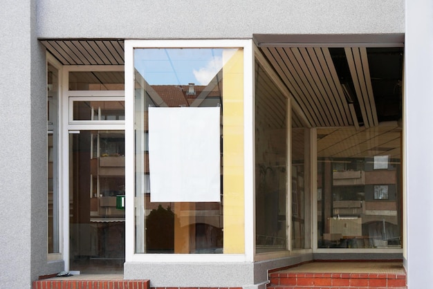 Signo en blanco en la ventana de la tienda vacía