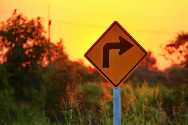 Signo de carretera contra el cielo durante la puesta del sol