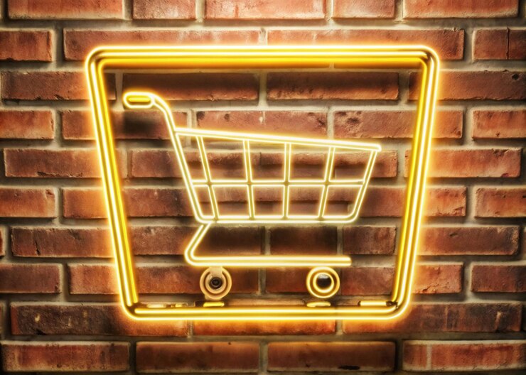 Foto signo de carrito de compras de neón con fondo de pared de ladrillo para la venta