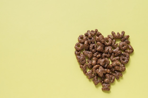 Signo del corazón del cereal de desayuno seco en forma de letras, copos de chocolate, comida útil para niños, vista superior