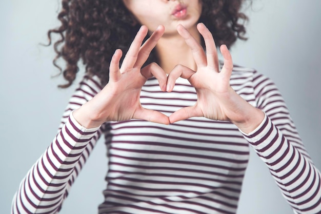 Signo de corazón de mano de mujer