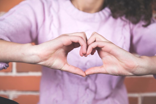 Signo de corazón de mano de mujer