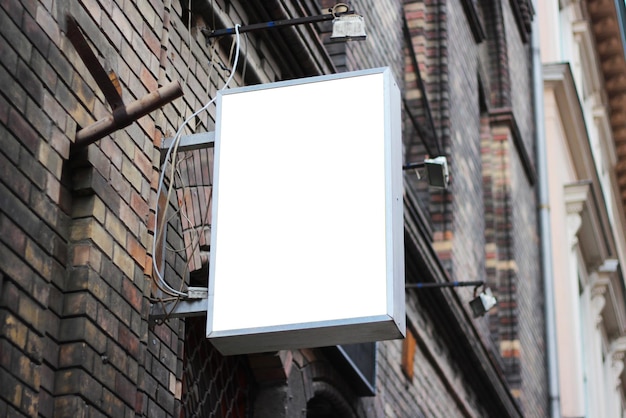 Signo cuadrado montado en una pared con entorno de ladrillo urbano para maqueta de publicidad Plantilla para la marca de logotipo e identidad corporativa de un restaurante de cafetería de tienda