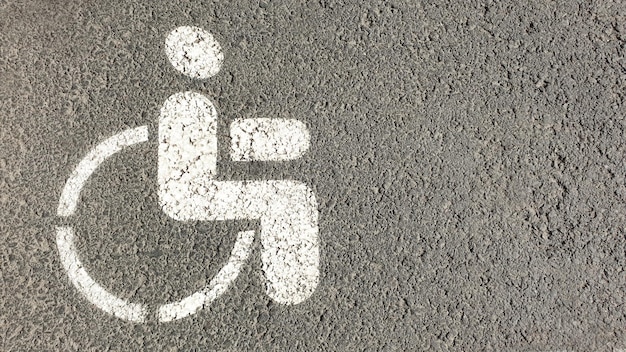 Signo de discapacitados pintado sobre asfalto