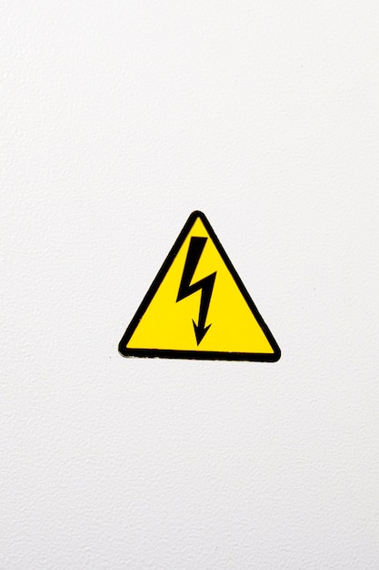 Foto signo de electricidad en una puerta de metal con llave