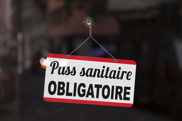 Foto signo con escrito en francés pass sanitaire obligatoire que significa en inglés pas obligatorio de salud