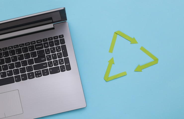 Foto signo de flechas recicladas y teclado portátil sobre fondo azul. vista superior