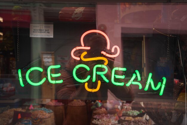 Signo de helado de neón en vista de la ventana verde y naranja