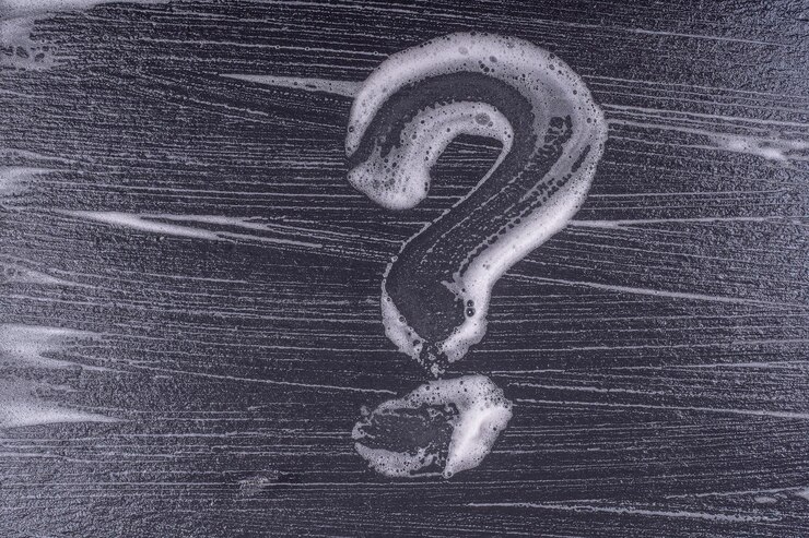 Foto signo de interrogación hecho de espuma de jabón sobre un fondo negro textura de espuma abstracta sobre fondo negro burbujas de espuma de jabón fondo oscuro abstracto