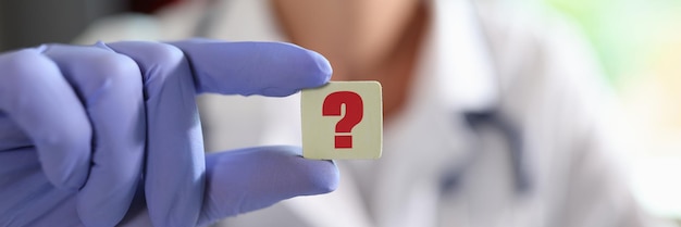 Signo de interrogación en la mano del médico general o cardiólogo en la clínica médico en línea