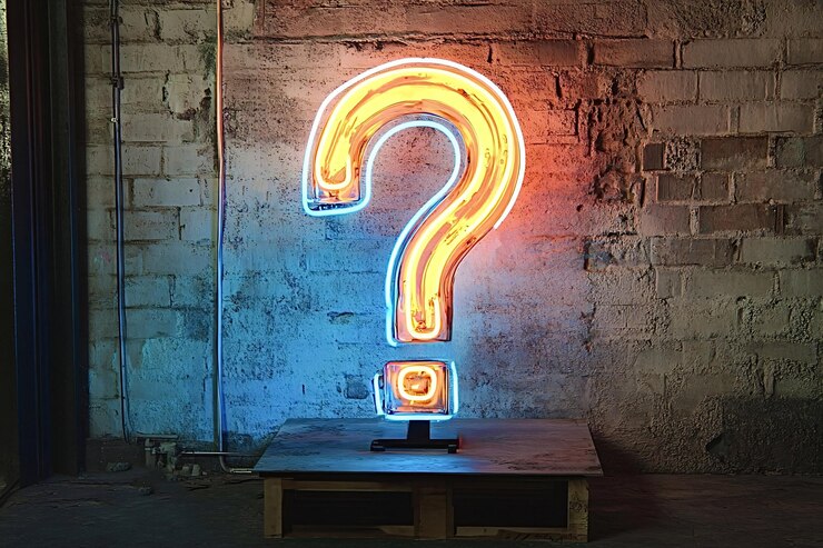 Foto un signo de interrogación de neón brillante contra una pared de ladrillo