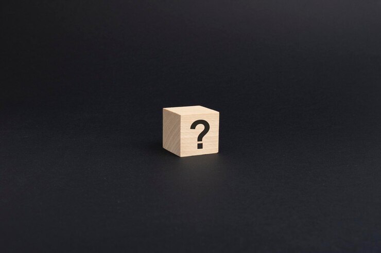Foto signo de interrogación sobre bloque de madera sobre fondo negro con espacio de copia