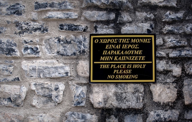 signo de no fumar griego en una pared