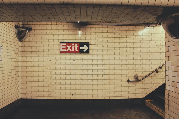 Foto signo de salida en la pared de azulejos en la estación de metro