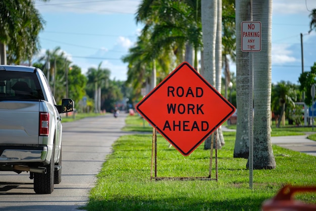 Signo de trabajo vial en el sitio de la calle como advertencia a los coches sobre obras de construcción y servicios públicos