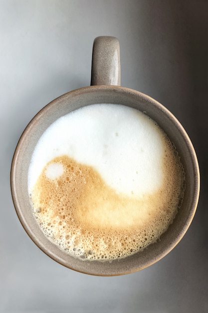 Foto signo de yin yang en espuma de leche en la taza de café