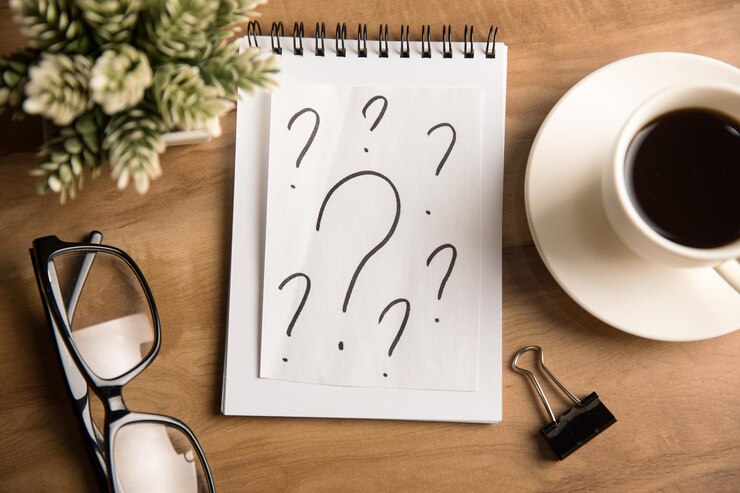 Foto signos de interrogación en papel en el escritorio