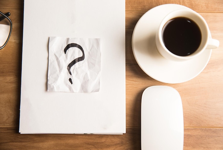Foto signos de interrogación en papel en el escritorio