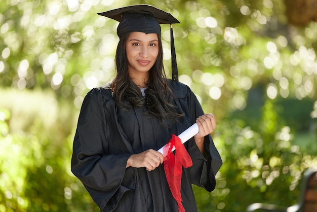 Sigue adelante y sé glorioso Retrato de una mujer joven que sostiene su diploma el día de la graduación