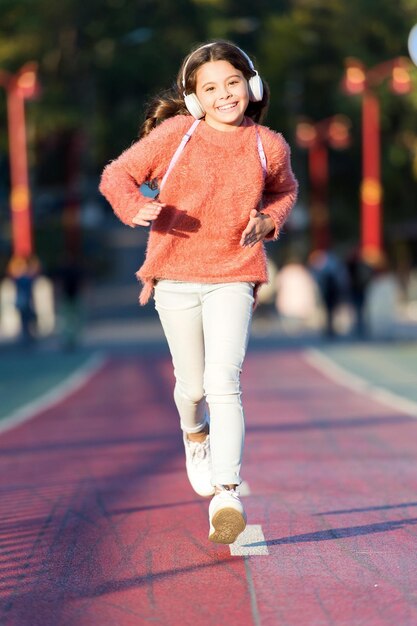 Sigue moviendote. Niña en pista de atletismo. El niño pequeño disfruta de la actividad deportiva. Pequeño aficionado al deporte. Deporte y fitness. Llevando al límite.