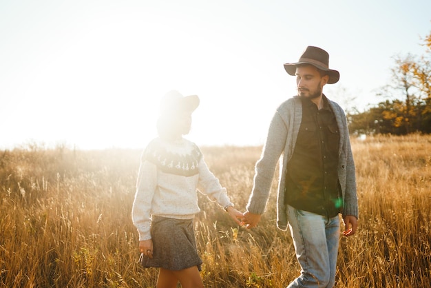 Sígueme Los hombres llevan a la chica detrás de él Encantadora pareja hipster Pareja con hermosos sombreros