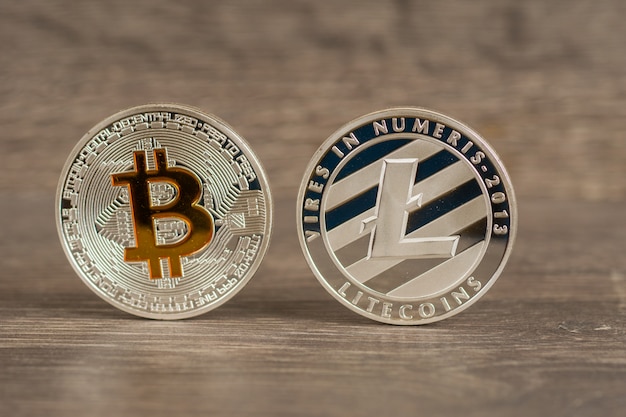 Silber Bitcoin und Litecoin Metallmünzen auf Holztisch