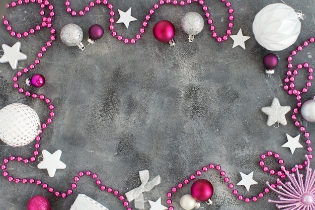 Silber und rosa Weihnachtsdekorationen auf einem grauen Hintergrund