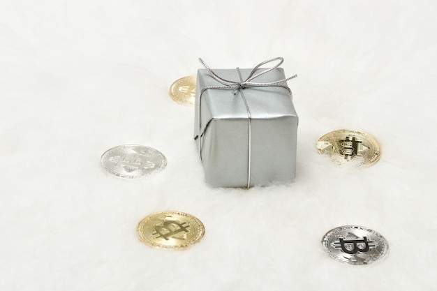 Foto silberne geschenkbox und bitcoins-münzen auf weißem hintergrund
