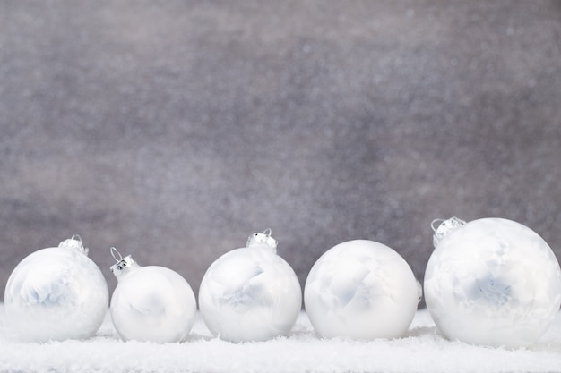 Silberne Weihnachtskugeln auf glänzendem Hintergrund