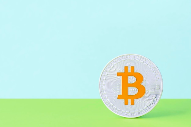 Silberner Bitcoin mit einem goldenen Symbol auf einem hellen zweifarbigen Hintergrund mit Kopierbereich Kryptowährung auf dem Konzept der virtuellen Handelsbörse Positiver finanzieller Geschäftshintergrund