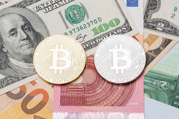 Silberner und goldener Bitcoin auf Euro- und Dollarhintergrund. Hochauflösendes Foto.