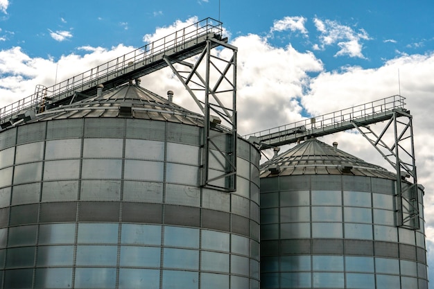 Silbersilos auf Agro-Produktionsanlage zur Verarbeitung, Trocknung, Reinigung und Lagerung von landwirtschaftlichen Produkten, Mehl, Getreide und Getreide. Große Eisenfässer mit Getreide