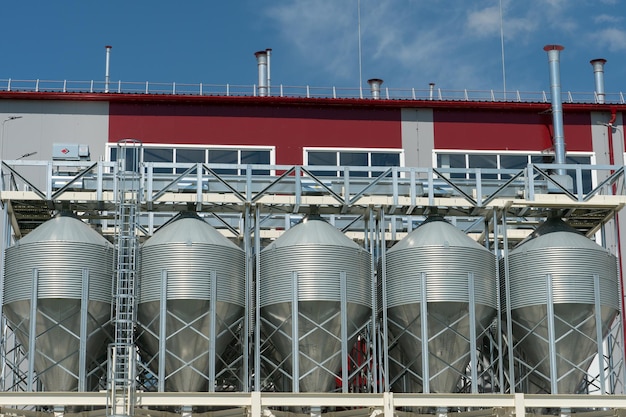 Silbersilos auf Agro-Produktionsanlage zur Verarbeitung, Trocknung, Reinigung und Lagerung von landwirtschaftlichen Produkten, Mehl, Getreide und Getreide. Große Eisenfässer mit Getreide