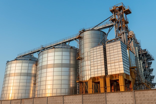 Silbersilos auf Agro-Produktionsanlage zur Verarbeitung, Trocknung, Reinigung und Lagerung von landwirtschaftlichen Produkten, Mehl, Getreide und Getreide. Große Eisenfässer mit Getreide