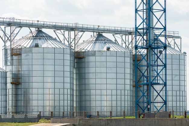 Silbersilos auf Agro-Produktionsanlage zur Verarbeitung, Trocknung, Reinigung und Lagerung von landwirtschaftlichen Produkten, Mehl, Getreide und Getreide. Große Eisenfässer mit Getreide