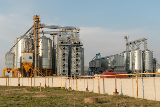 Silbersilos auf Agro-Produktionsanlage zur Verarbeitung, Trocknung, Reinigung und Lagerung von landwirtschaftlichen Produkten, Mehl, Getreide und Getreide. Große Eisenfässer mit Getreide