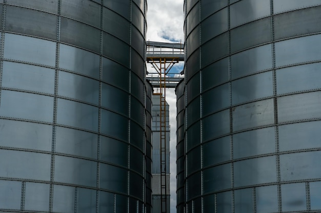 Silbersilos auf Agro-Produktionsanlage zur Verarbeitung, Trocknung, Reinigung und Lagerung von landwirtschaftlichen Produkten, Mehl, Getreide und Getreide. Große Eisenfässer mit Getreide