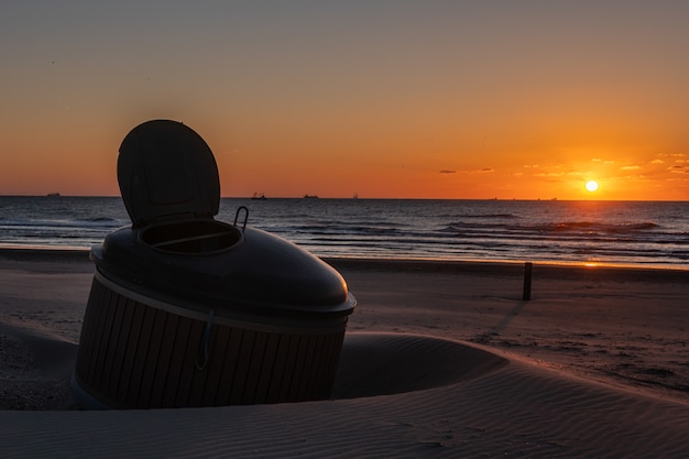 Silhouete de diseño de construcción metálica como taburete en la playa del mar en la hermosa puesta de sol con mar sereno en el