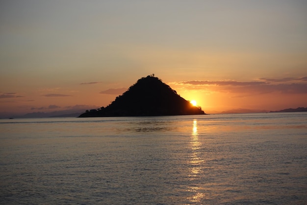 Foto silhouette berg vor dem meer gegen den himmel bei sonnenuntergang