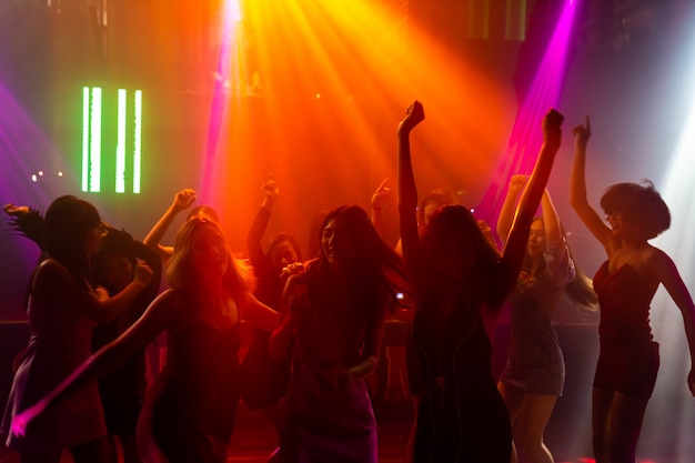 Silhouette Bild von Menschen tanzen in Disco Nachtclub zu Musik von DJ auf der Bühne