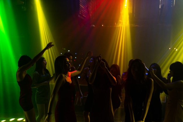 Silhouette Bild von Menschen tanzen in Disco Nachtclub zu Musik von DJ auf der Bühne