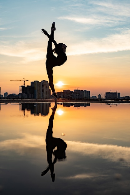 Silhouette der Ballerina, die während des Sonnenuntergangs Konzept der Individualität Kreativität im Freien aufführt