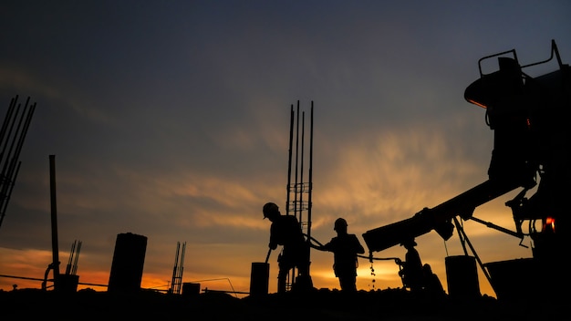 Silhouette der Gruppe von Arbeitnehmern, die auf einer Baustelle arbeiten.