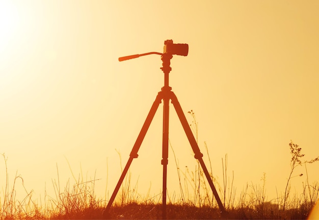 Silhouette der Kamera auf Stativ bei Sonnenuntergang