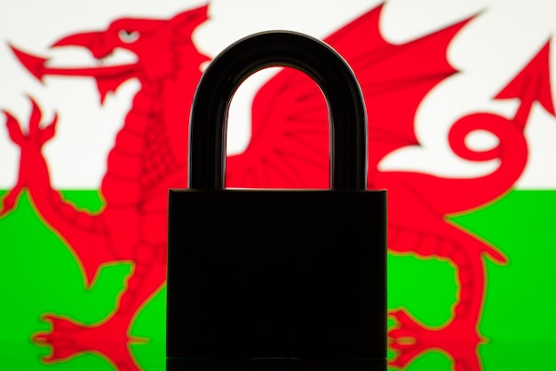 Silhouette der Sperre mit Flagge von Wales im Hintergrund Konzept der geschlossenen Grenzen von Wales-Sanktionen