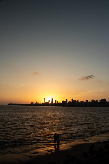 Silhouette der Stadt am Meer gegen den Himmel beim Sonnenuntergang