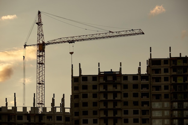 Silhouette des Baukrans neben dem im Bau befindlichen Gebäude bei Sonnenuntergang